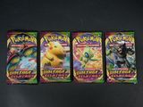 trois paquets de cartes à collectionner Pokémon posés sur une table