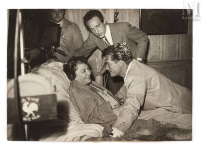 photographie en noir et blanc représentant un groupe d'hommes et de femmes dans un lit