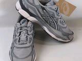 a pair of grey sneakers with a tag on the side