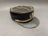 un chapeau noir orné d'une bordure dorée sur fond gris