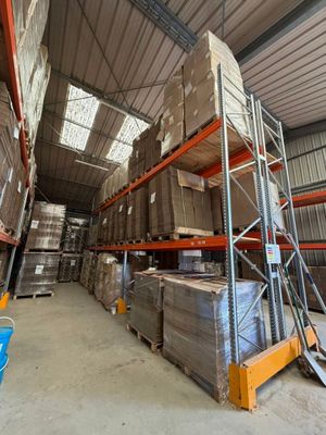 des rayonnages dans un entrepôt, sur lesquels sont posées des palettes et des cartons