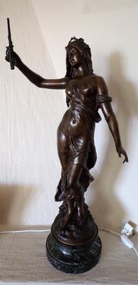 a statue of a woman holding a knife on top of a table
