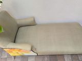 a chaise lounger with a plant in the corner of the room