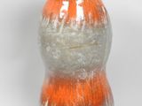 un vase blanc et orange posé sur une surface blanche