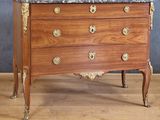 une commode en bois avec un plateau en marbre, posée sur un parquet en bois dur