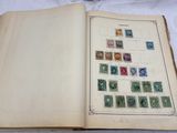 un livre ouvert avec des timbres, posé sur une table
