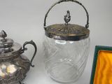 a glass jar with a lid sitting next to a silver teapot