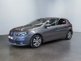 the grey car is parked in a room with a white wall