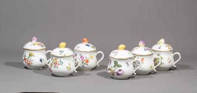 several white and gold teapots with colorful flowers and birds on them