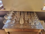 many empty wine glasses sitting on a wooden table