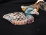 two wooden ducks that are sitting on a black surface