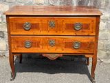 an old wooden chest of drawers sitting on top of a stone wall