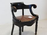 a black chair with a brown leather seat on a white floor