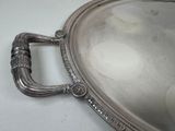 a silver tray with a handle on a white table