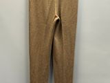 a brown pants hanging on a hanger against a white wall