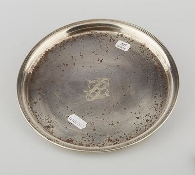 a silver plate with a bird on it sitting on top of a table