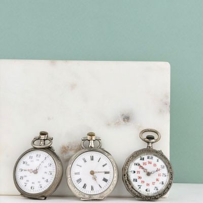 trois horloges posées les unes à côté des autres sur un bloc de marbre