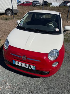a small red and white car parked on the side of the road