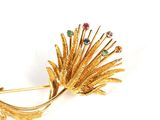 yellow gold brooch with multi colored stones and leaves