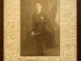 an old photo of a man in a suit and tie holding a cane