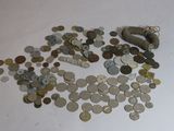 un tas de pièces de monnaie posées sur une table, à côté d'un rouleau de billets