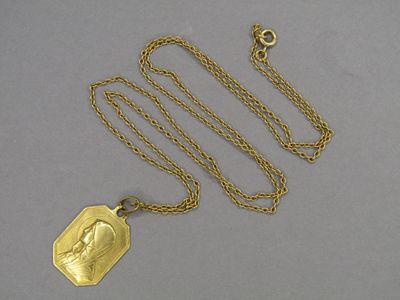 an image of a gold necklace with a picture of a woman on it
