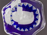 assiette en verre violet et blanc ornée d'un motif de rayons bleus en forme d'étoile
