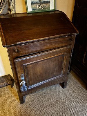 une petite armoire en bois surmontée d'un tableau