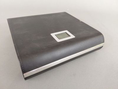 un livre noir sur lequel est posée une horloge numérique
