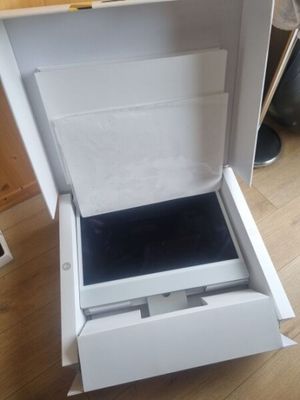 a open white box with a black lid on a wooden floor