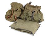 Plusieurs sacs sont alignés sur une surface blanche, avec un sac au milieu.