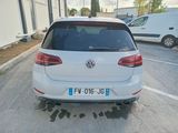 a white vw golf parked in a parking lot