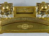 a gold desk set with two inkwells on top of it