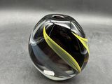 a glass marble with a yellow stripe on it sitting on top of a table