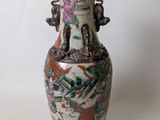 a vase with a painting on it sitting on a table