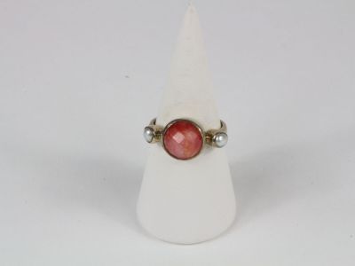 a close up of a ring with a red stone on it