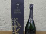 une bouteille de champagne posée sur une table à côté d'une boîte