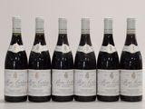 six bottles of wine lined up in a row on a table