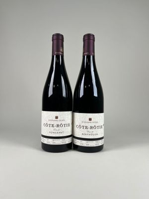 two bottles of red wine sitting next to each other on a table
