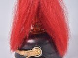 a red wig on top of a helmet on a white surface