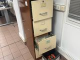 a tall cabinet with drawers in the corner of a room
