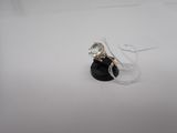 une photo d'une bague en diamant posée sur un socle noir, sur une surface blanche