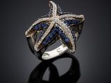 a close up of a starfish ring with blue and white diamonds