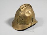 a gold fireman ' s helmet on a white surface