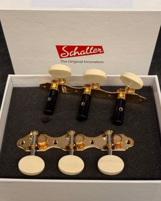a white box with four gold tone guitar heads in it
