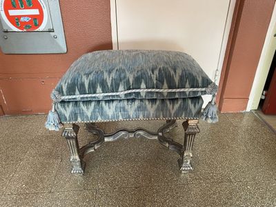 un repose-pieds rembourré orné d'un motif bleu et blanc