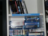 a white book shelf filled with dvds and movies