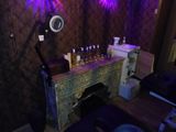 a table with bottles of alcohol on it in a room with purple lights
