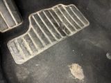 a dirty floor in a car with a dirty floor mat