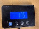 a digital clock on a table next to a cell phone